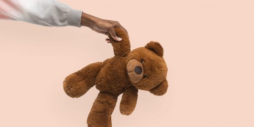 Teddy bear held by a hand for charity campaign